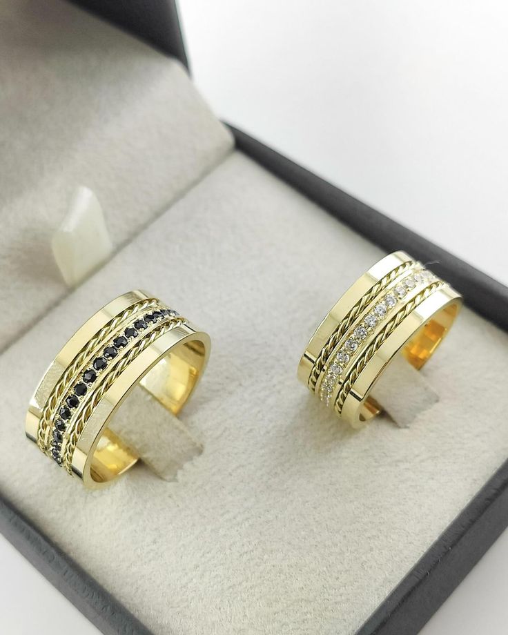 Par do Modelo reto, com fio trançado em baixo relevo nas laterais, parte central com pedras (80 em média no par), cravejadas em toda circunferência da aliança, 10mm largura em Ouro Amarelo - Tradicional 18k/750