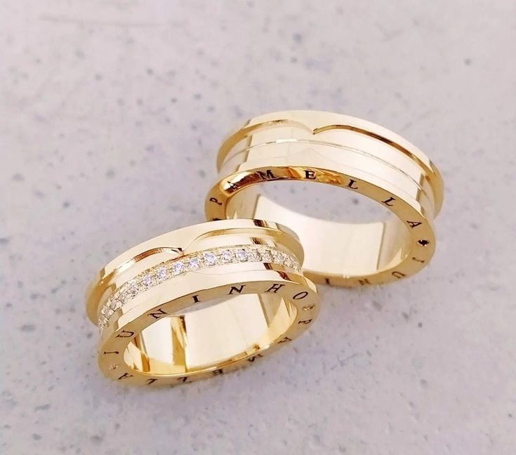 Par do Modelo Especial, espesso, com gravação nas bordas com 9mm. Modelo 1: cravação de pedras (40 na média), em toda a circunferência da aliança. Modelo 2: um friso central em Ouro Amarelo - Tradicional 18k/750